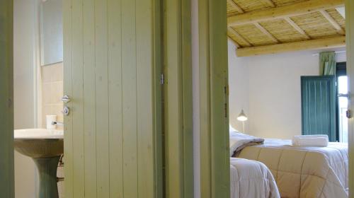 a bathroom with a bed and a sink in a room at Casale Laurus in Locogrande