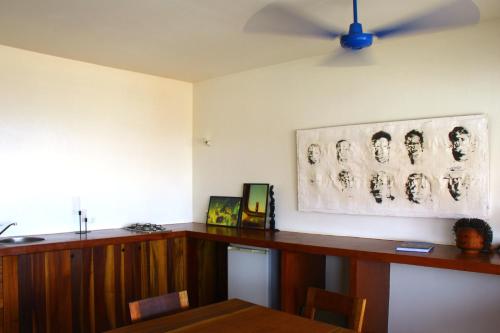 ein Esszimmer mit einem Tisch und einem Gemälde an der Wand in der Unterkunft Paz Apartment in Mindelo