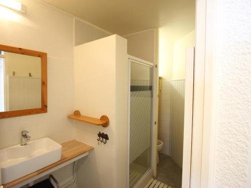 een witte badkamer met een wastafel en een douche bij Studio Chamrousse, 1 pièce, 4 personnes - FR-1-549-111 in Chamrousse