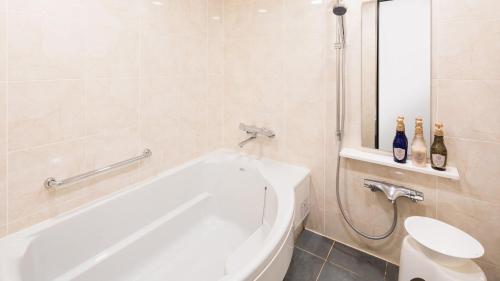 a bathroom with a white tub and a toilet at JR-East Hotel Mets Komagome in Tokyo