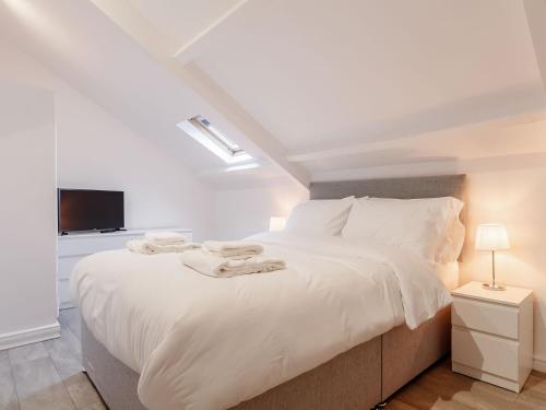 a bedroom with a large white bed with a tv at The Barn-uk32860 in Alltwen