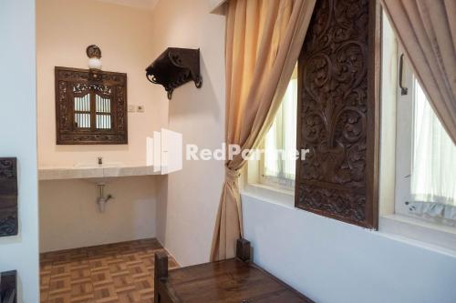 ein Ankleidezimmer mit einem Fenster und einer Holztür in der Unterkunft Monginsidi Guest House Syariah Malioboro Yogyakarta Mitra RedDoorz in Yogyakarta