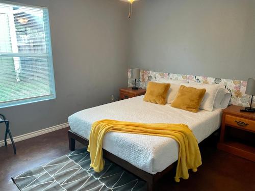 - une chambre dotée d'un lit avec des couvertures jaunes dans l'établissement The Burger and Frey Street House, à Stephenville