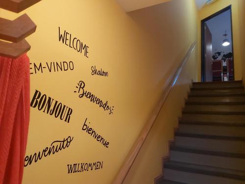 un escalier avec des mots sur un mur jaune dans l'établissement Ushuaia JAUKE Departamentos, à Ushuaia