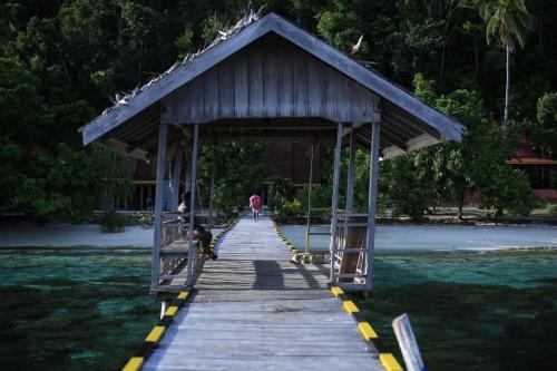 a wooden boardwalk with a small building on it at Amoryg Resort and Dive Raja Ampat in Pulau Mansuar