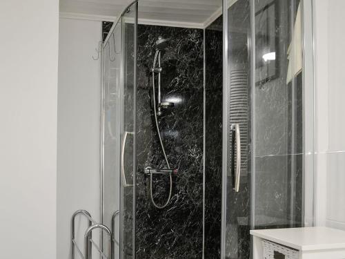 a shower with a glass door in a bathroom at View Cottage in Settle