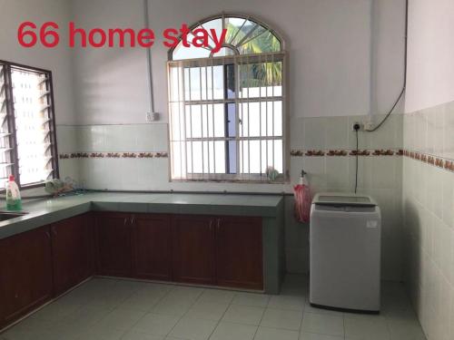 a kitchen with a sink and a window and a trash can at 66 Semi-D Homestay in Teluk Intan