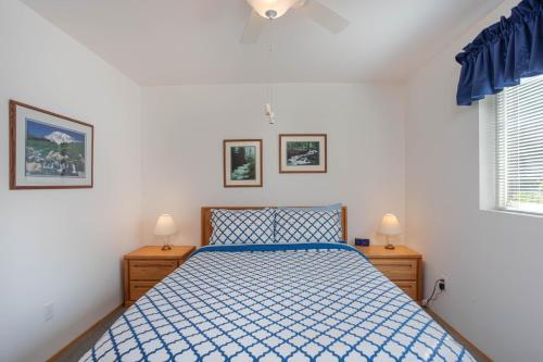 ein Schlafzimmer mit einem blauen Bett und zwei Nachttischen in der Unterkunft Walk to Downtown * 6 Guests * Pets * A/C! * No Stairs! in Leavenworth