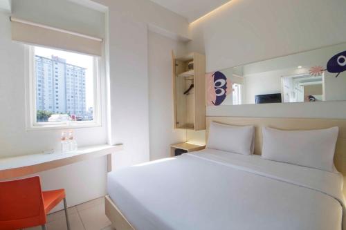 a bedroom with a white bed and a window at Cleo Hotel Basuki Rahmat in Surabaya