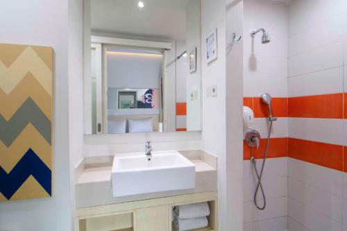 a bathroom with a sink and a mirror at Cleo Hotel Basuki Rahmat in Surabaya