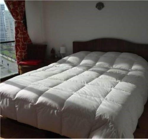 1 cama blanca grande en un dormitorio con ventana en Departamento San Martin Frente Playa, en Viña del Mar