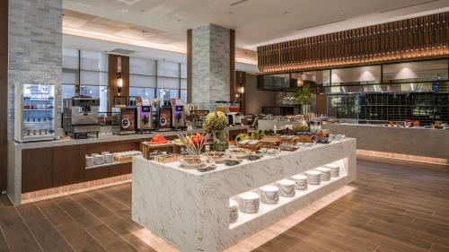 a restaurant with a counter with plates of food at Grand Banyan Hotel in Tainan