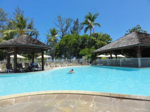 a person in a swimming pool at a resort at Hotel Le Recif, Ile de la Reunion in Saint-Gilles les Bains