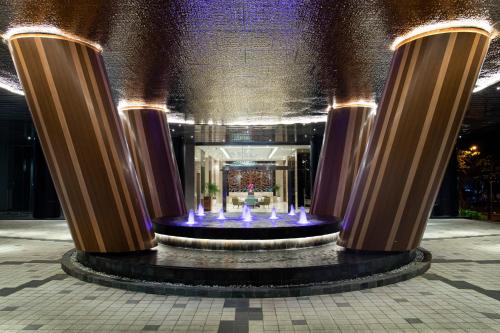 a fountain in the middle of a building with columns at Trembesi Hotel in Serpong