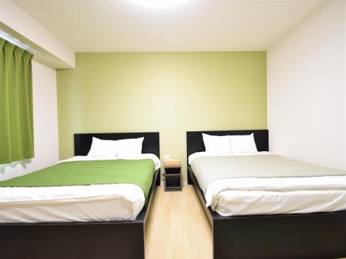 2 Betten nebeneinander in einem Zimmer in der Unterkunft Regariain - Vacation STAY 84627 in Okayama