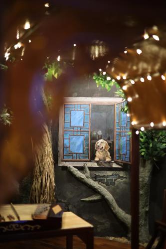a painting of a dog looking out of a window at The Garden Hotel Guangzhou - Discover 26 cultural treasures with hotel Golden Tour Guide in Guangzhou