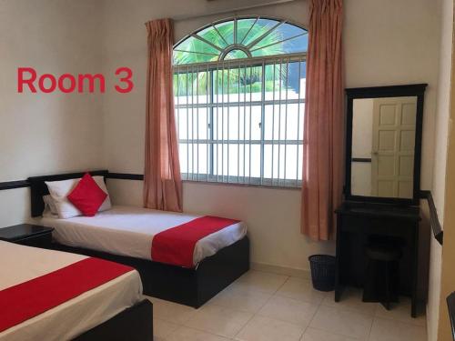 a hotel room with two beds and a window at 66 Semi-D Homestay in Teluk Intan