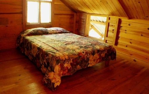 a bed in a wooden room in a cabin at Centro Ecológico Montaña Verde in Rivas