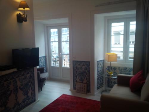 een woonkamer met 2 deuren en een televisie bij Costa Castle Apartment in Lissabon
