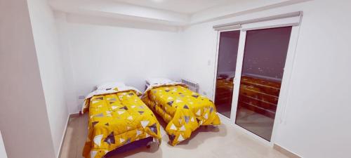 dwa łóżka w pokoju z oknem w obiekcie Los argentos w mieście Ushuaia