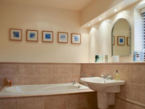 a bathroom with a tub and a sink and a mirror at Woodland View in Whitewell