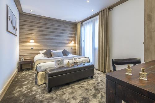 a bedroom with a bed and a desk in a room at Hotel La Chaudanne in Méribel