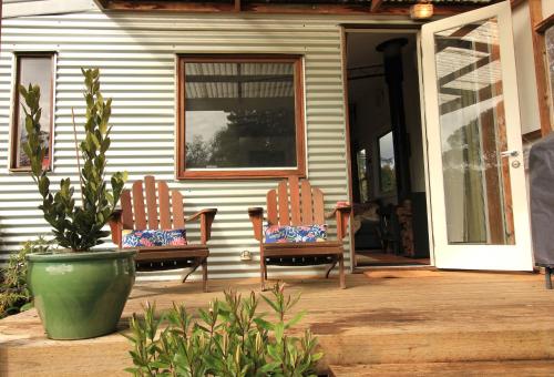 two chairs sitting on the porch of a house at Stoney Creek Cottage in Trentham