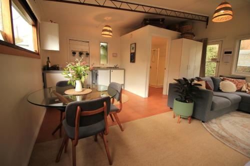 a living room with a table and a couch at Stoney Creek Cottage in Trentham