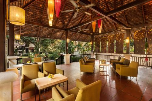 restauracja z kanapami, stołami i krzesłami w obiekcie Lanna Dusita Riverside Boutique Resort w mieście Chiang Mai