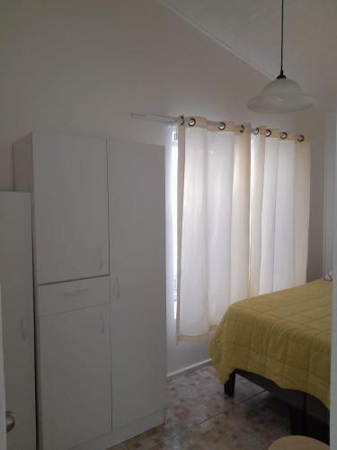 a bedroom with a bed and a window with white curtains at Cabanas bahia inglesa in Bahia Inglesa