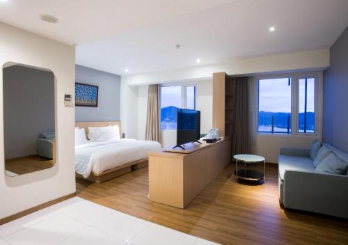 Habitación de hotel con cama y sofá en Hotel Santika Premiere Ambon, en Ambon