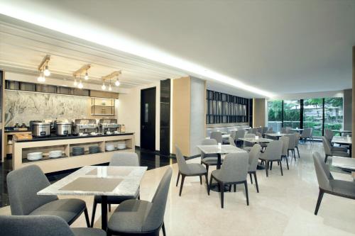 a restaurant with tables and chairs and a kitchen at Somerset Sudirman Jakarta in Jakarta