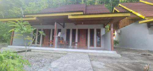 a small house with a balcony with tables and chairs at Amoryg Resort and Dive Raja Ampat in Pulau Mansuar