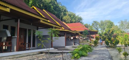 a row of buildings with trees in the background at Amoryg Resort and Dive Raja Ampat in Pulau Mansuar