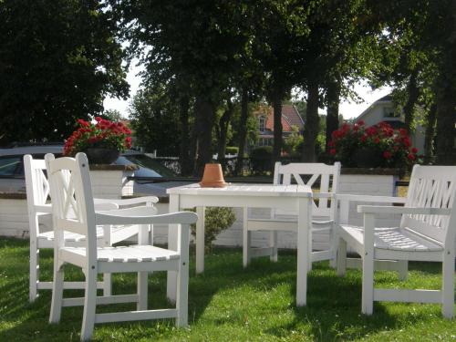 a group of white chairs and a table with a cone on it at Monicas Rumsuthyrning in Borgholm