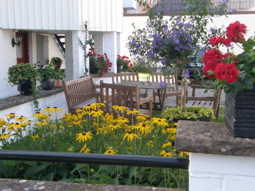a garden with a table and chairs and flowers at Monicas Rumsuthyrning in Borgholm