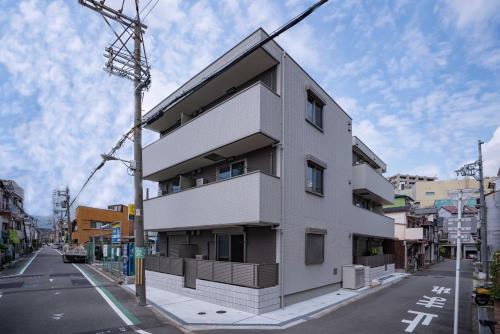 a white building on the side of a street at 震雲マンション105 in Osaka
