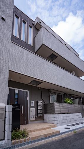 uma casa de tijolos com uma varanda ao lado em 震雲マンション105 em Osaka