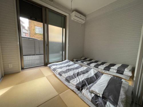 um quarto com duas camas e uma janela em 震雲マンション105 em Osaka
