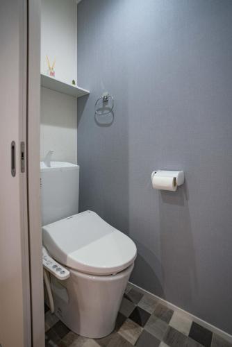 uma casa de banho com um WC branco e um rolo de papel higiénico em 震雲マンション105 em Osaka
