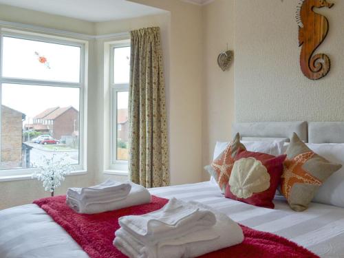 a bedroom with towels on a bed with a window at Sea The Stars in Hornsea