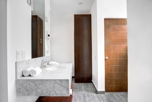 a bathroom with a sink and a wooden door at Mayan Water Hotel in Playa del Carmen
