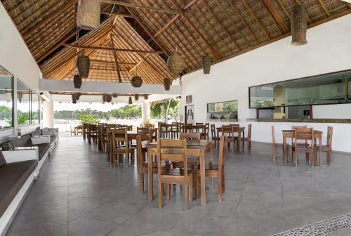 a restaurant with wooden tables and chairs in a room at Mayan Water Hotel in Playa del Carmen