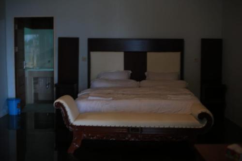 a bedroom with a bed with a bench in it at Amoryg Resort and Dive Raja Ampat in Pulau Mansuar