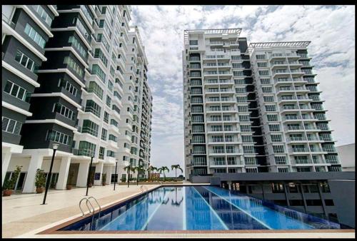 two tall buildings with a swimming pool in front of them at Sekinchan High Level SeaView Homestay in Sekincan