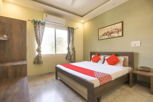 a bedroom with a bed and a window at Summer Palms in Kangra