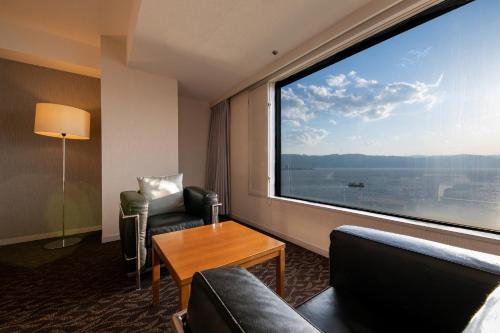 um quarto com uma grande janela num quarto de hotel em Hotel Beniya em Suwa