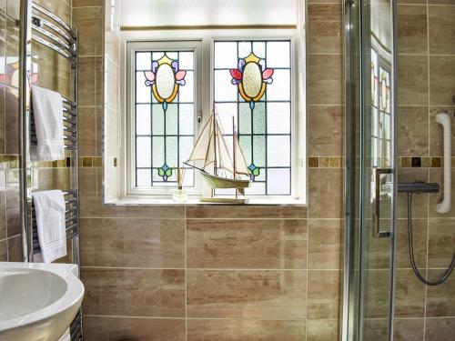 La salle de bains est pourvue d'un lavabo et d'une fenêtre avec un voilier. dans l'établissement Chaseley House, à Blackpool