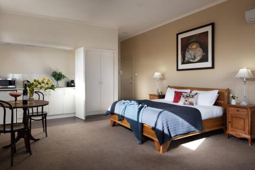 a bedroom with a bed and a table and a kitchen at Daylesford House Studio in Daylesford