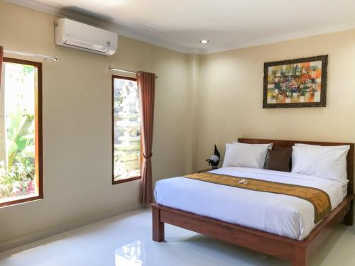 1 dormitorio con 1 cama y 2 ventanas en Villa Dira Ubud, en Ubud